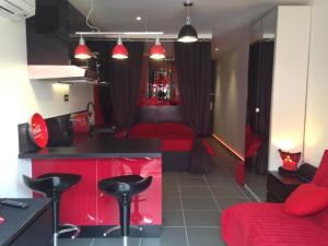 een kamer met 2 bedden en een keuken met rode meubels bij La Cage Village Naturiste in Cap d'Agde