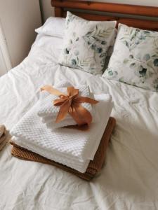 ein weißes Handtuch mit einem Bogen auf dem Bett in der Unterkunft Entire house Sheffield s10booking in Stannington