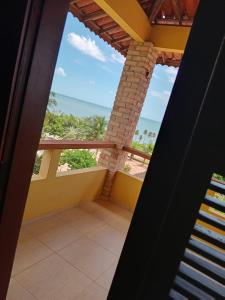 um quarto com uma varanda com vista para o oceano em Village Lagoinha Ceará em Paraipaba