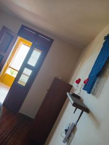 a bedroom with a blue door and a room with a table at Village Lagoinha Ceará in Tigre
