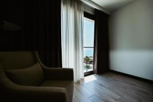 a living room with a couch and a window at Palladium Beach Hotel in Dhërmi