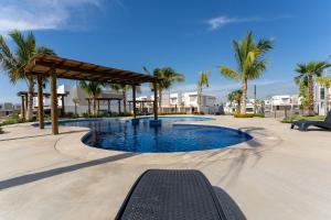 una piscina en un complejo con palmeras en New°Family°Pool°Spacious°Backyard°King°BBQ°Gated, en Mazatlán