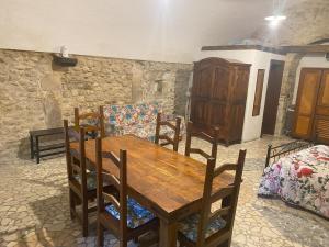 a dining room with a wooden table and a couch at La casetta di Bianca in Sulmona