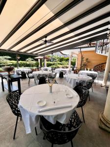 un restaurante con mesas y sillas con mantel blanco en Civico 29 rooms, en Peschiera del Garda