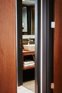 a bathroom with a sink and a mirror at Palladium Beach Resort- Luxury Leading Hotels, Private Beach Included in Dhërmi +80 photos