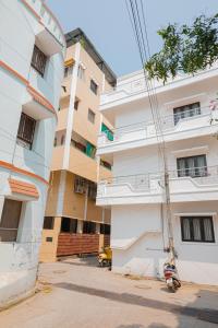 un edificio blanco alto junto a una calle en Maison Annai en Pondicherry