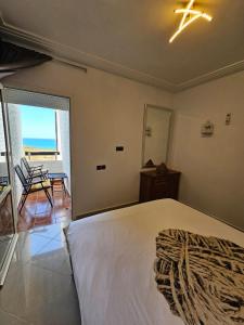 a bedroom with a bed and a view of the ocean at Asilah Marina Golf Sea Ocean and Golf view in Asilah