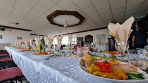 une longue table avec des assiettes de nourriture dans l'établissement Erika Panzió, à Ditrău 14 autres photos