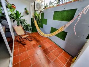 um quarto com rede de descanso e uma parede com plantas em Hermoso Apartamento Cerca a la Playa Puerto Colombia em Puerto Colombia