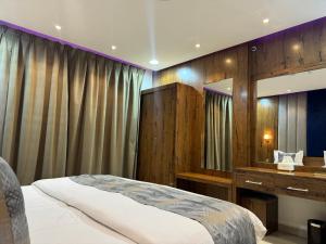 1 dormitorio con cama, tocador y espejo en الاتحاد الذهبية للشقق المخدومة 1, en Al Hofuf