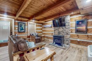 a living room with a fireplace in a log cabin at Up the Creek in Gatlinburg