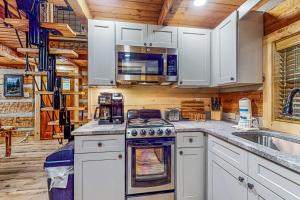 a kitchen with a stove and a microwave at Up the Creek in Gatlinburg