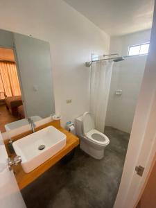 uma casa de banho com um lavatório, um WC e um espelho. em Killamoon House Paracas em Paracas
