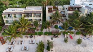 an aerial view of a hotel on a beach with palm trees at Mereva Tulum in Tulum