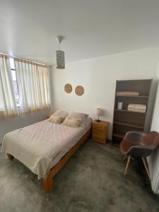 1 dormitorio con 1 cama y 1 silla en Killamoon House Paracas en Paracas