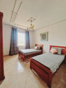 - une chambre avec 2 lits et une fenêtre dans l'établissement ORAN Frange Maritime, à Oran