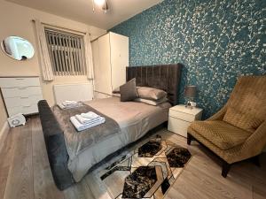een slaapkamer met een bed en een stoel bij 5 Bed 5 Bath / Brick Lane Central London E1 in Londen