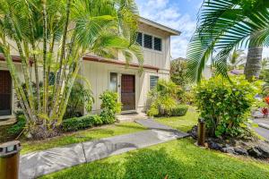 a house with palm trees in the front yard at Ultimate Oceanfront Townhome with AandC On Kona Coast in Kailua-Kona