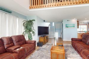 a living room with brown leather furniture and a flat screen tv at Lucky Shores in North Topsail Beach