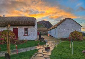 a group of buildings with a sunset in the background at Mary Ellen's - Doonalt in Glencolumbkille