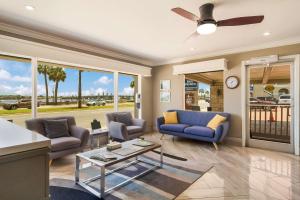 a living room with blue couches and a ceiling fan at Best Western Historic Bayfront in Saint Augustine