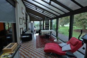 sala de estar con sofá rojo y ventana grande en Pied des Milles Etang - Les Capucins, en Faucogney-et-la-Mer