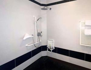eine Dusche im Bad mit schwarzen und weißen Fliesen in der Unterkunft Best Western Le Cheval Blanc -Vue sur le port-plein centre ville in Honfleur