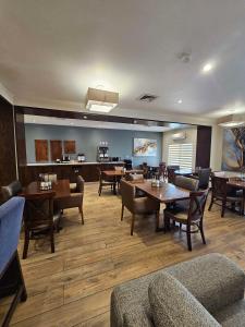 a dining room with tables and chairs and a kitchen at Best Western Plus Chihuahua Aeropuerto in Chihuahua