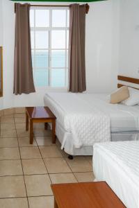 um quarto de hotel com duas camas e uma janela em Hotel Casa Amelia em Flores