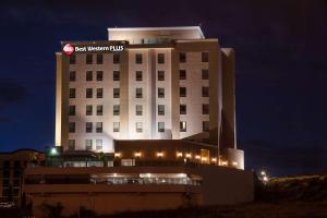 a large white building with a sign on top of it at Best Western Plus Chihuahua Juventud in Chihuahua