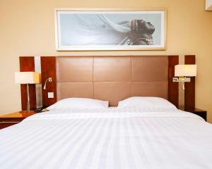 a bed in a hotel room with a picture on the wall at Park Inn by Radisson, Kigali in Kigali