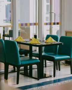 Park Inn by Radisson, Kigali في كيغالي: طاولة طعام وكراسي عليها مناديل صفراء