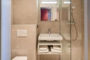 uma casa de banho com um lavatório e um chuveiro em Brit Hotel Nantes La Beaujoire Parc Expo em Nantes