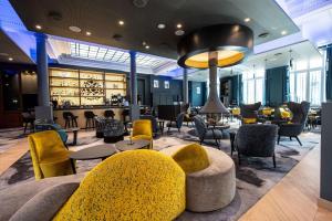 een lobby met stoelen en tafels en een bar bij Best Western Premier Le Chapitre Hotel and Spa in Remiremont