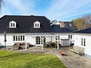 a white house with a patio in the yard at 5 person holiday home in Øster Assels-By Traum in Øster Assels +28 photos