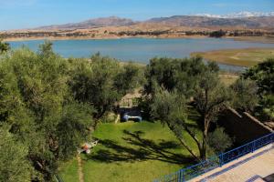 een uitzicht op een meer met bomen en een hek bij Dar Nfis piscine hydro massage Privée, jet ski, Agafay in Lalla Takerkoust