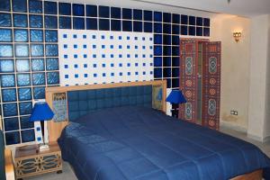 een slaapkamer met een blauw bed en blauwe betegelde muren bij Dar Nfis piscine hydro massage Privée, jet ski, Agafay in Lalla Takerkoust