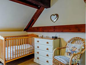 a baby room with a crib and a dresser at 1 Bed in Lyme Regis 90145 in Lyme Regis