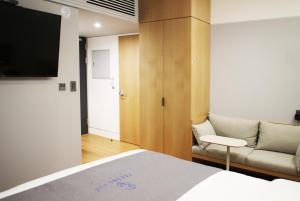1 dormitorio con cama, sofá y TV en Hotel Parangvue en Goseong