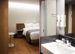 ein Hotelzimmer mit einem Bett und einem Waschbecken in der Unterkunft Hotel Parangvue in Goseong