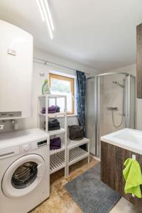 a bathroom with a washing machine and a shower at Idyllic holiday home - relaxation place in Leibnitz