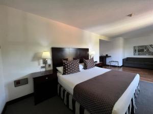 a hotel room with a large bed and a couch at Hotel GH Guaparo Suites Valencia in Valencia +43 photos