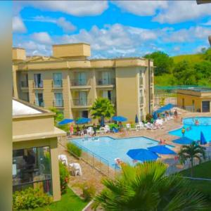 a hotel with a swimming pool and a resort at Flat_Quartie_aldeia_das_aguas in Barra do Piraí