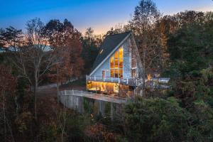 uma casa na floresta com uma grande janela em Stylish Smoky Mountains Cabin with Views and Game Room em Sevierville