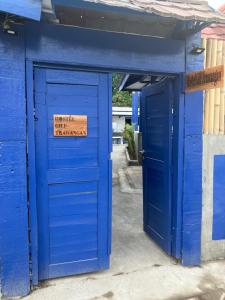 un bâtiment bleu avec une porte bleue et un panneau sur celle-ci dans l'établissement Hostel Gili Trawangan, à Gili Trawangan