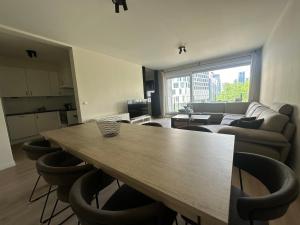 een woonkamer met een houten tafel en stoelen bij Apartment in Brussels City with Beautiful View in Brussel