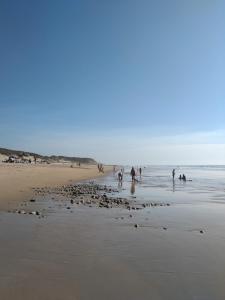 un grupo de personas jugando en el agua en una playa en Monte da Bela Vista, Colos, en Colos
