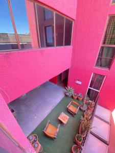 an overhead view of a pink building with chairs and plants at Hotel Flamingos in Guadalajara