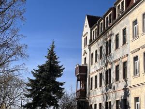 a clock tower in front of a building with a christmas tree at Gäste-Appartements Morgensonne & Sonnenschein in Dresden