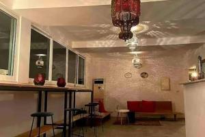 Cette chambre comprend un bar avec des chaises et un lustre. dans l'établissement Ossoma House, à Luanda